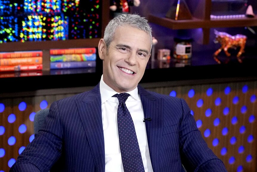Andy Cohen smiles at the camera on the set of Watch What Happens Live
