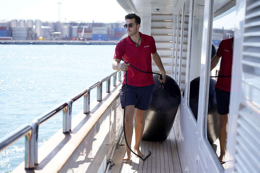 Max Holz carrying a fender aboard the Mustique yacht.