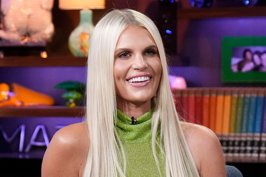 Madison LeCroy smiling in a green, metallic, halter neck dress at the WWHL clubhouse.