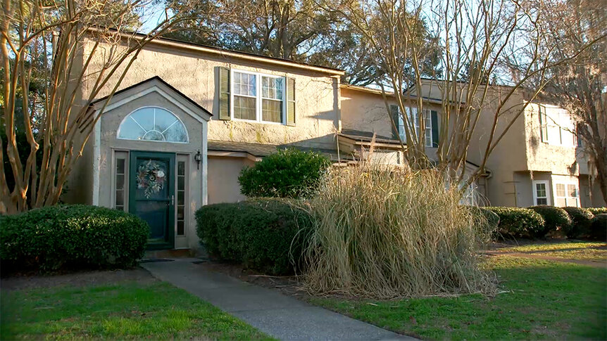 The exterior of Taylor Ann Green's home with bushes and grass in the front yard.