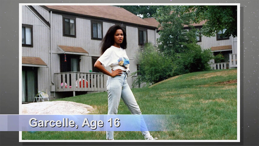 Garcelle Beauvais at 16 years old standing in front of a house wearing a t-shirt and jeans.