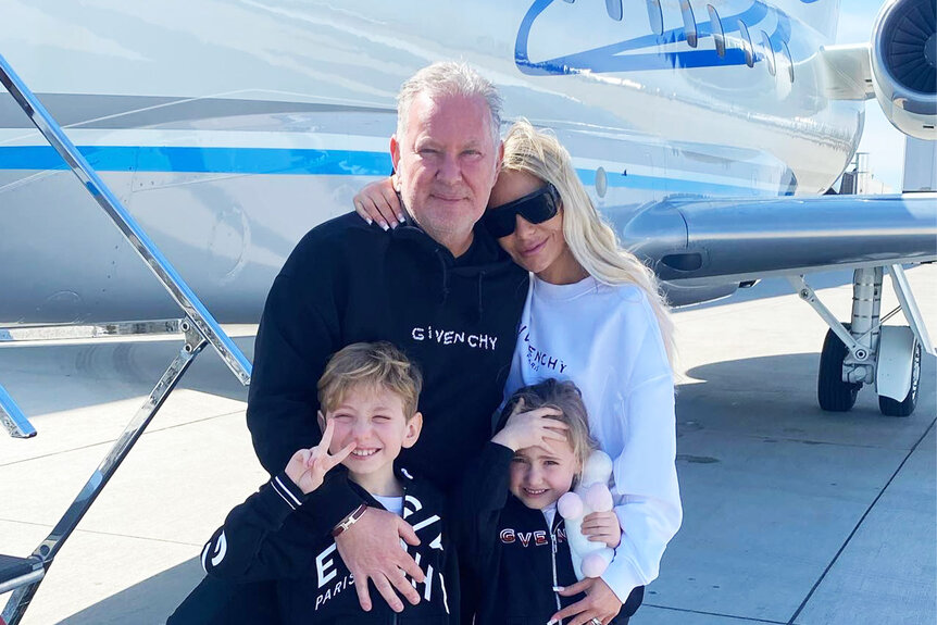 Dorit Kemsley posing with Paul "PK" Kemsley and her kids, Phoenix and Jagger, in front of a plane.