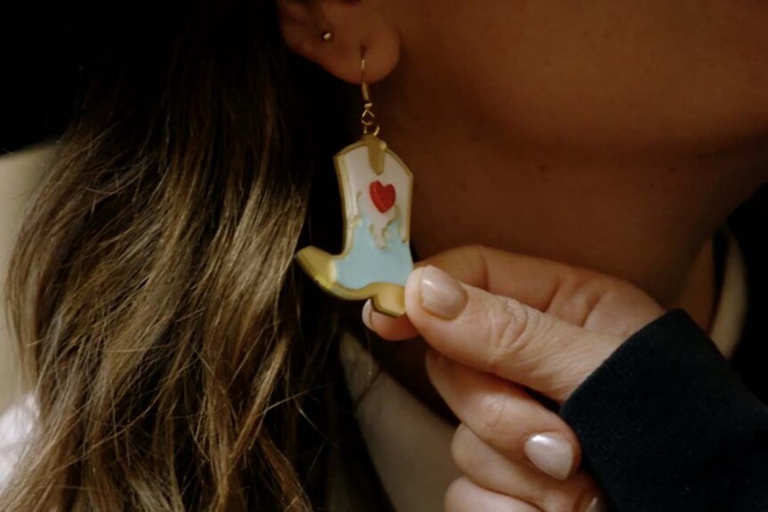 A hand holds Katie Flood's earrings from Tom Schwartz on Winter House Season 3 Episode 5.