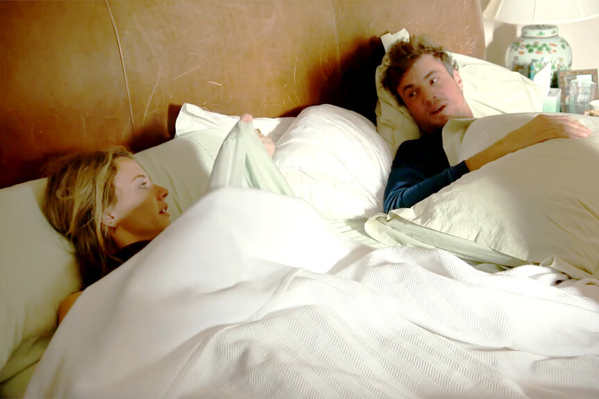 Taylor Ann Green and Shep Rose speak under the covers of a large bed in Southern Charm Season 9 Episode 10
