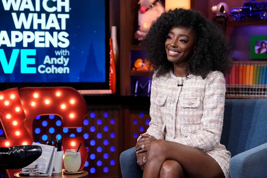 Venita Aspen smiles in a tweed skirt set on Watch What Happens Live With Andy Cohen Season 20 Episode 191.
