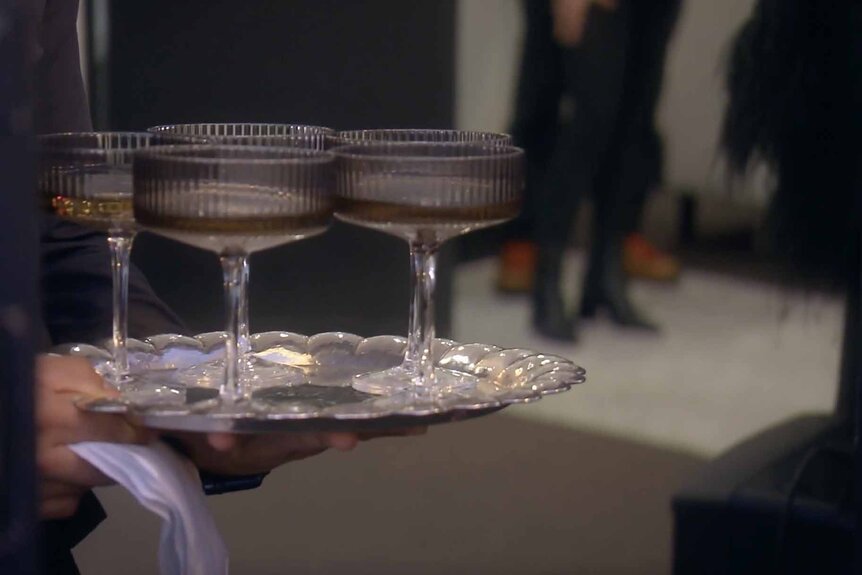 A server holds a platter of drinks in crystal glasses appears in The Real Housewives of Beverly Hills Season 13 Episode 8.