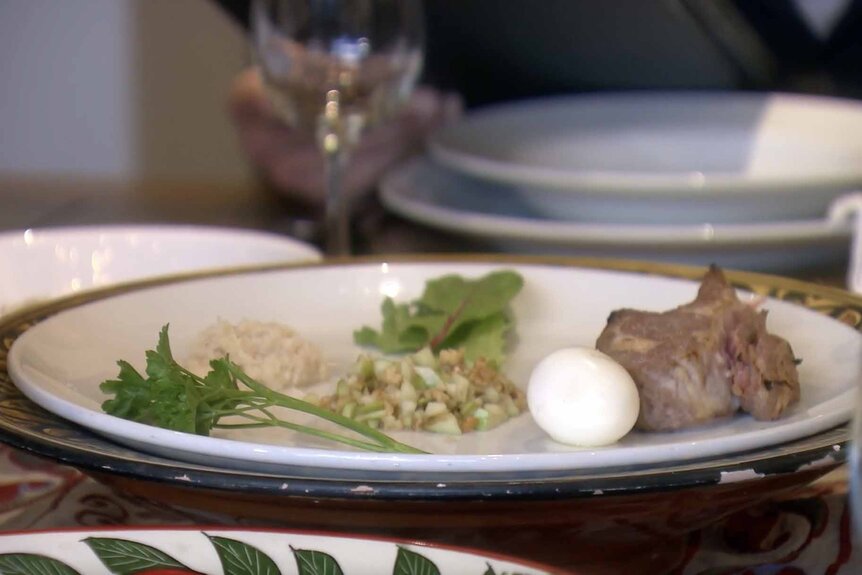 Crystal Kung Minkoff's Passover Seder meal featuring greens, meat, and an egg.