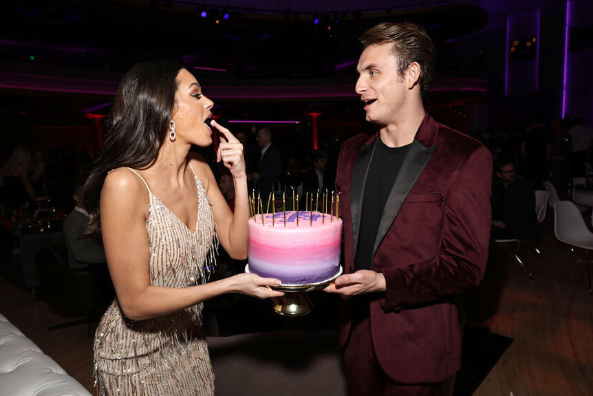 Ally Lewber and James Kennedy holding a cake at the Vanderpump Rules Season 11 premiere party