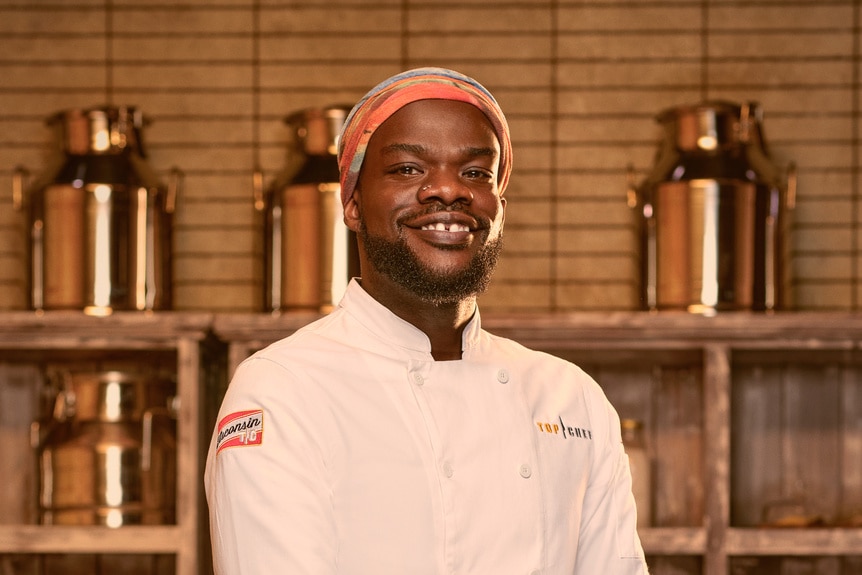 Charly Pierre wearing a chef's uniform in a kitchen pantry