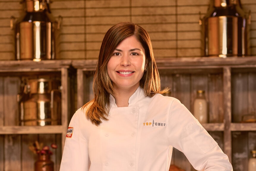 Laura Ozylimaz wearing a chef's uniform in a kitchen pantry