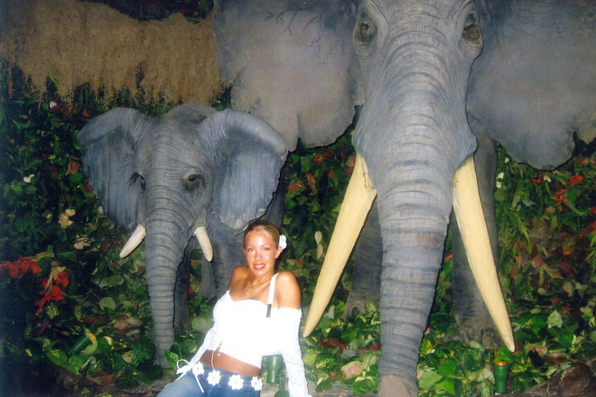 Lisa Hochstein smiling and posing with elephant statues.
