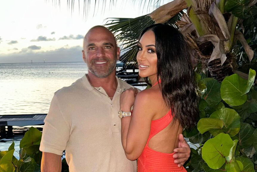 Melissa Gorga and Joe Gorga posing together in front of a sunset.