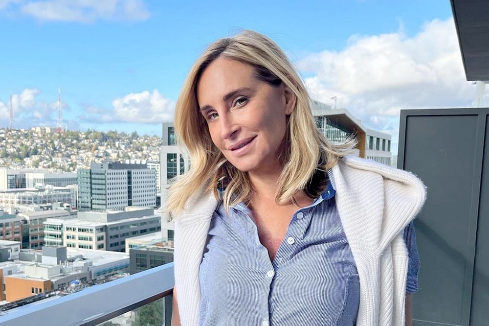 Sonja Morgan wears button up shirt and sweater on balcony