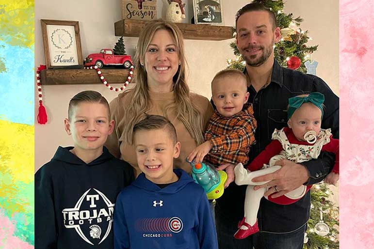 Briana Culberson, Ryan Culberson and their children smile together in front of a Christmas tree.