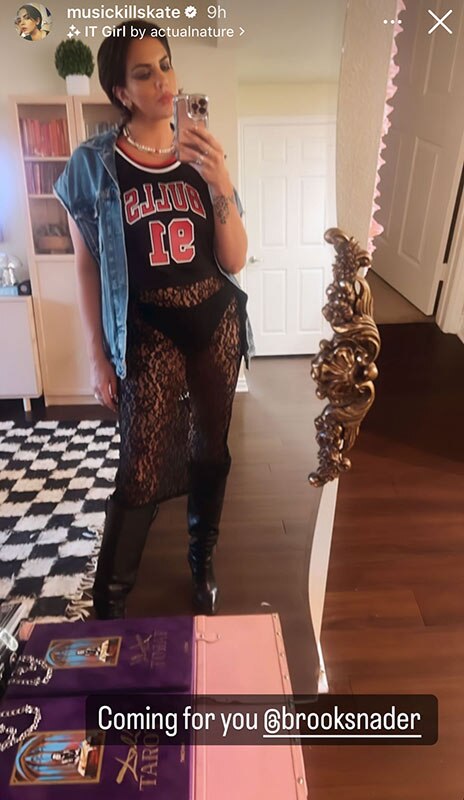 Katie wearing a cropped denim jacket over a basketball jersey and a sheer, lace, black bottom.
