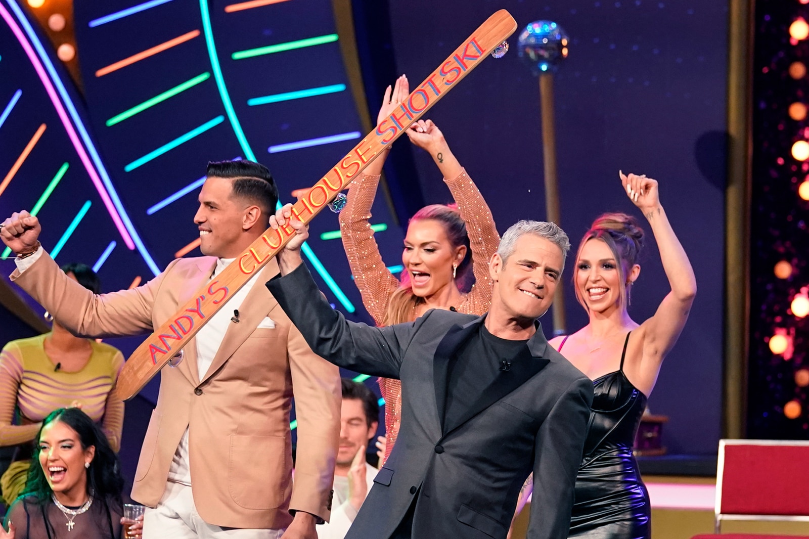 Andy Cohen holding the WWHL Shotski while on stage with Shouthern Charm, Vanderpump Rules, and Winter House casts.