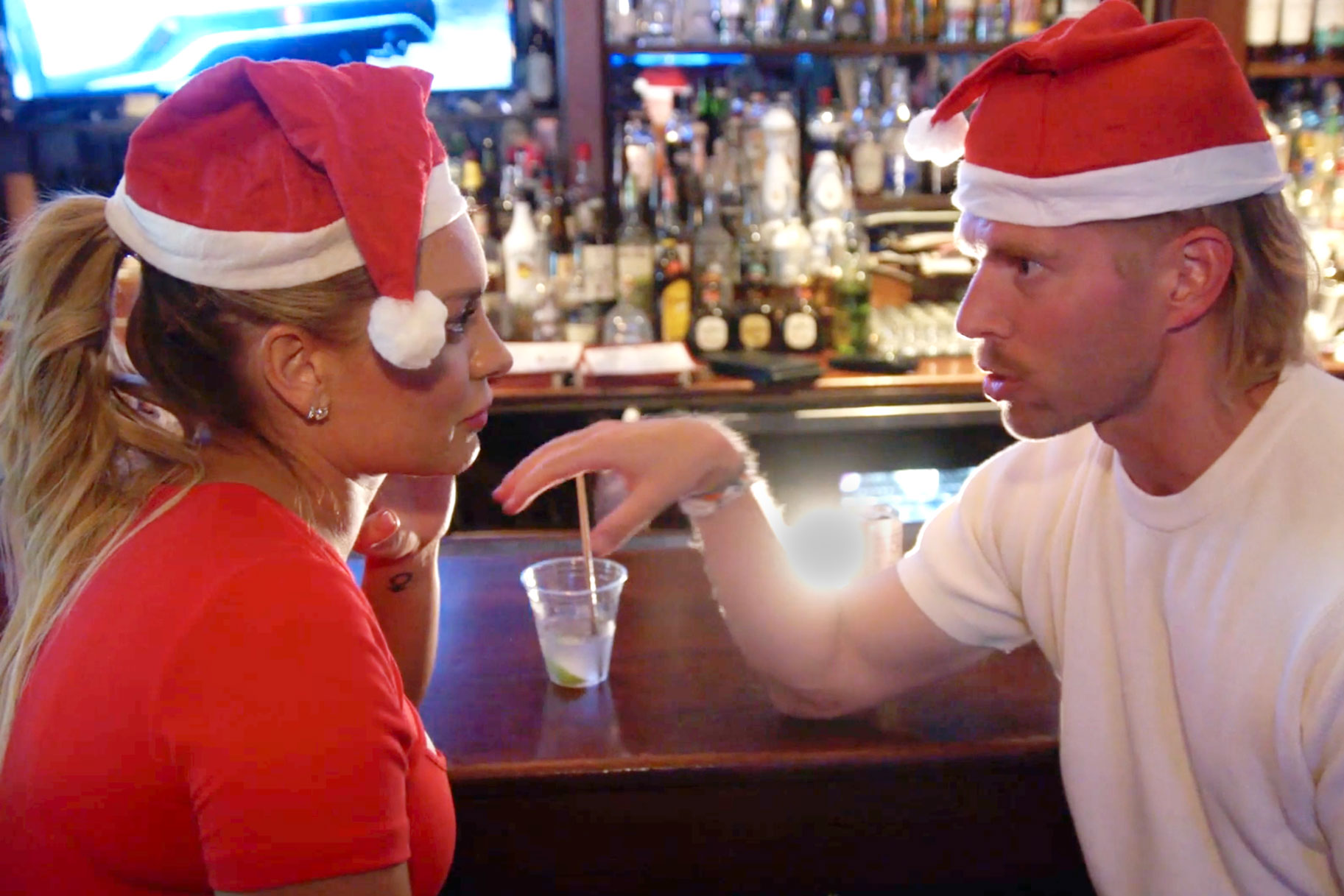 Lindsay Hubbard and Kyle Cooke at a bar wearing santa hats together.