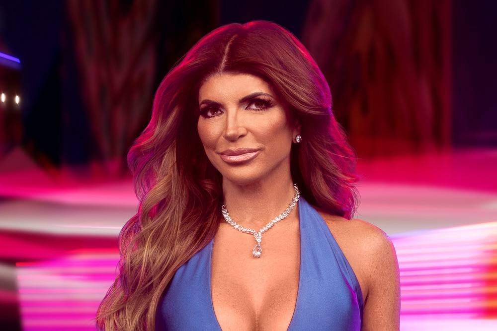 Teresa Giudice wearing a blue gown in front of a carnival backdrop.