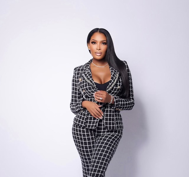 Brittany Eady wearing a black and white checkered suit in front of a white backdrop