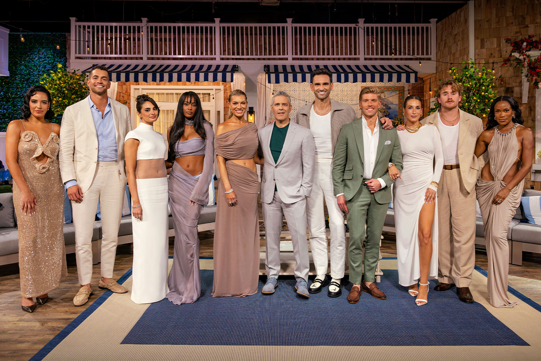 Andy Cohen and the Summer House cast posing together in front of a themed set.