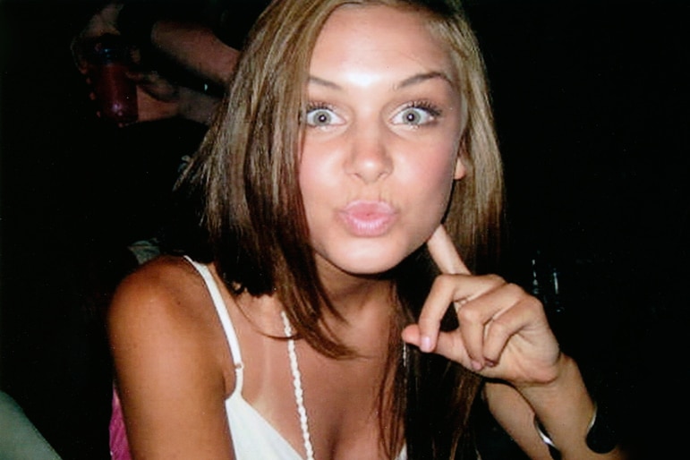 Lala Kent wears a white tank top and makes a funny face.