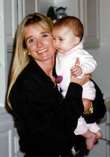 Kim Richards holding up a baby girl.