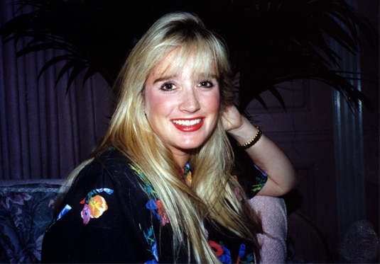 Kim Richards wearing a floral top and smiling.