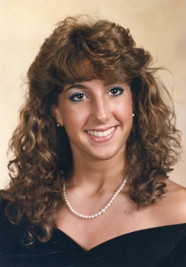 Young Jacqueline Laurita posing with a pearl necklace and black top.