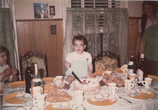 Teresa Giudice sitting on a kitchen table as a baby