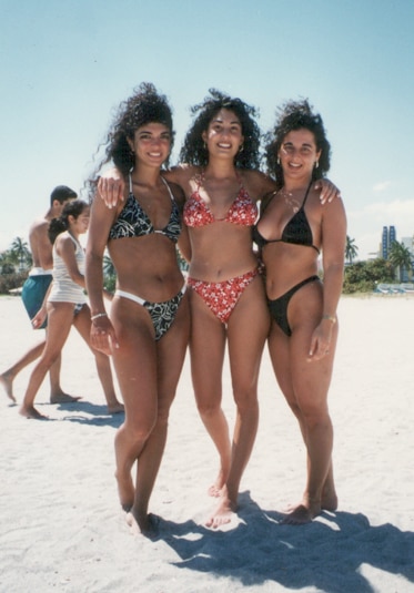 Teresa Giudice posing in a bikini on the beach with two friends