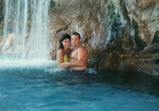 Teresa Giudice and Joe Giudice in bathing suits under a waterfall
