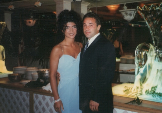 Teresa Giudice and Joe Giudice smiling together in front of a table