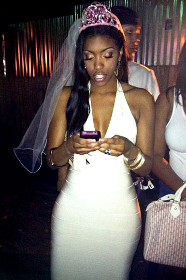 Porsha Williams wearing a white bodycon dress and a veil at her bachelorette.