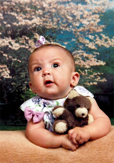 Ashlee Holmes, daughter of RHONJ Jacqueline Laurita as a baby holding a teddy bear