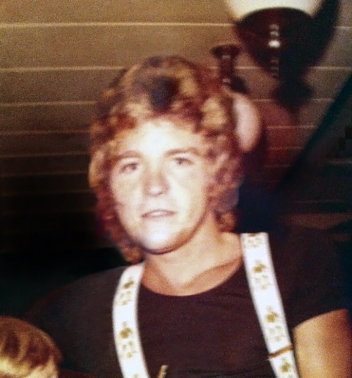 Ken in his youth wearing a black shirt and suspenders.