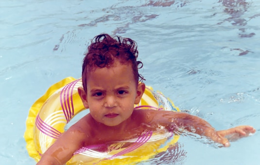Mauricio Umansky as a little boy in a floatie swimming in a pool