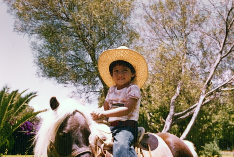 Mauricio Umansky as a little boy riding a horse.
