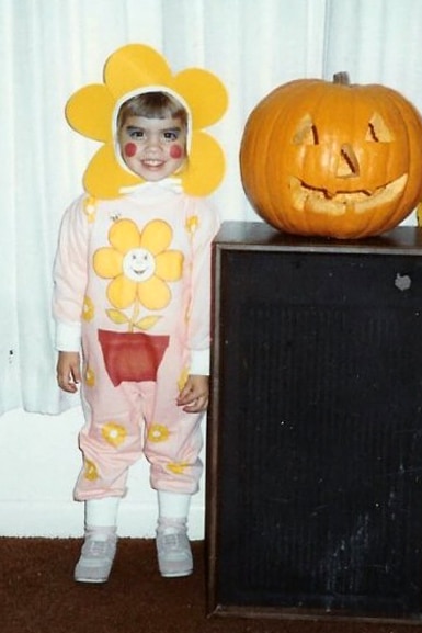 Katie Maloney dressed as a flower standing next to a pumpkin when she was a child.