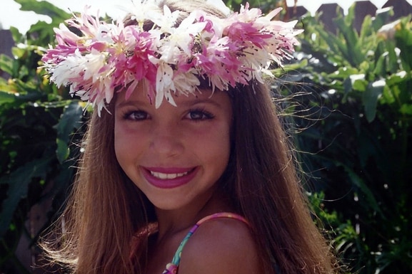 Scheana Shay smiles as she wears a flower crown as a young girl.