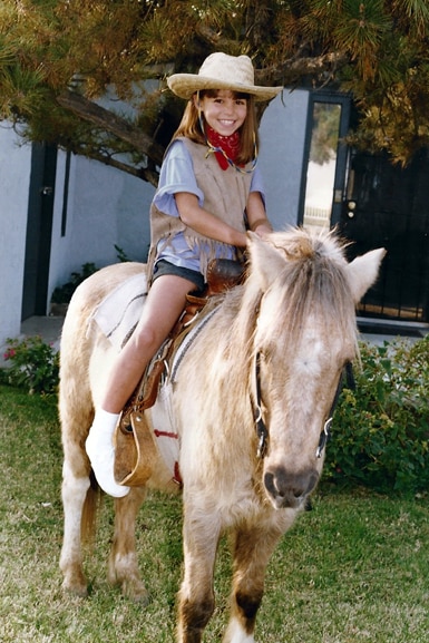 Scheana Shay wears a cowboy hat while riding a horse.