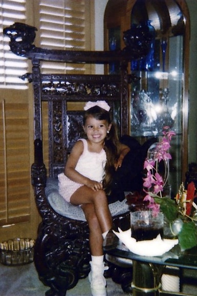 Scheana Shay sits in an oversized chair as a child.