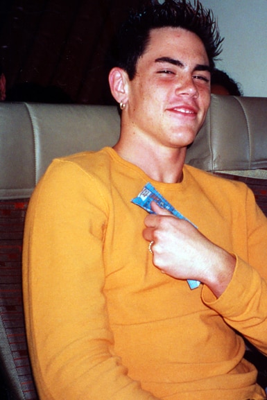Tom Sandoval sits and smiles as a teenager.