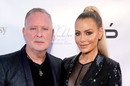 Dorit Kemsley and Paul Kemsley pose together in front of a step and repeat in Hollywood, California.
