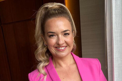 An Instagram photo of Daisy Kelliher smiling and wearing a hot pink blazer