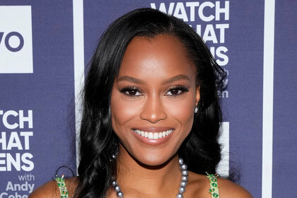 A headshot of Ciara Miller smiling in front of the step and repeat at Watch What Happens Live