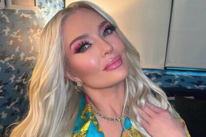 An Instagram photo of Erika Girardi posing in her home with pink eyeshadow and lipgloss