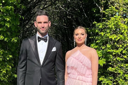 Lindsay Hubbard and Carl Radke dressed in formal wear standing in front of foliage.