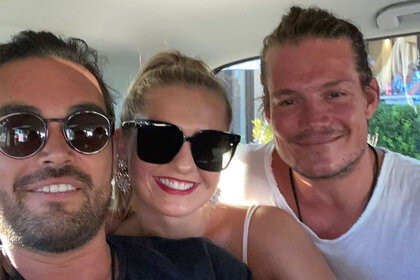Daisy, Gary, and Colin take a selfie together inside of a van.