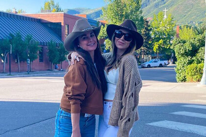 Kyle Richards and Farrah Britt pose together wearing hats outdoors.
