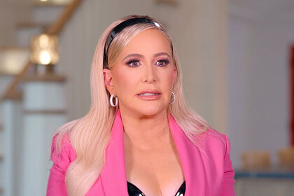 Shannon wearing a black headband and pink blazer with tears in her eyes during her interview.